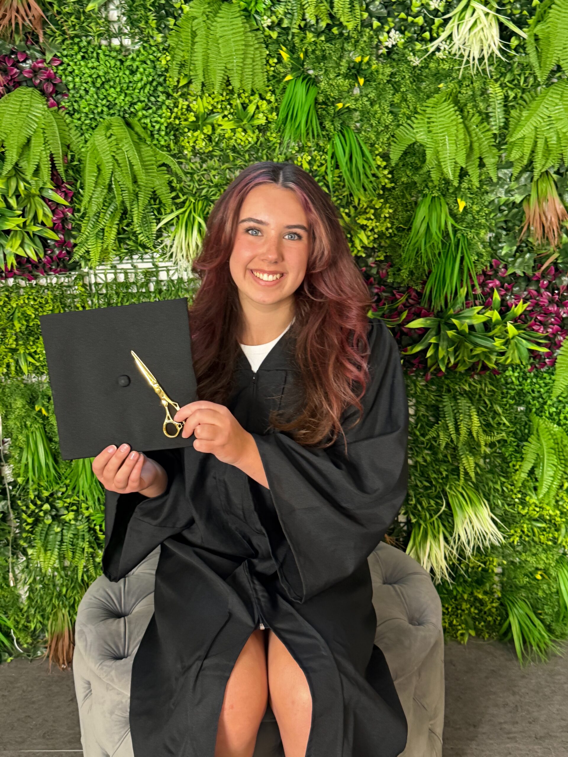 Cosmetology graduate holding her certificate