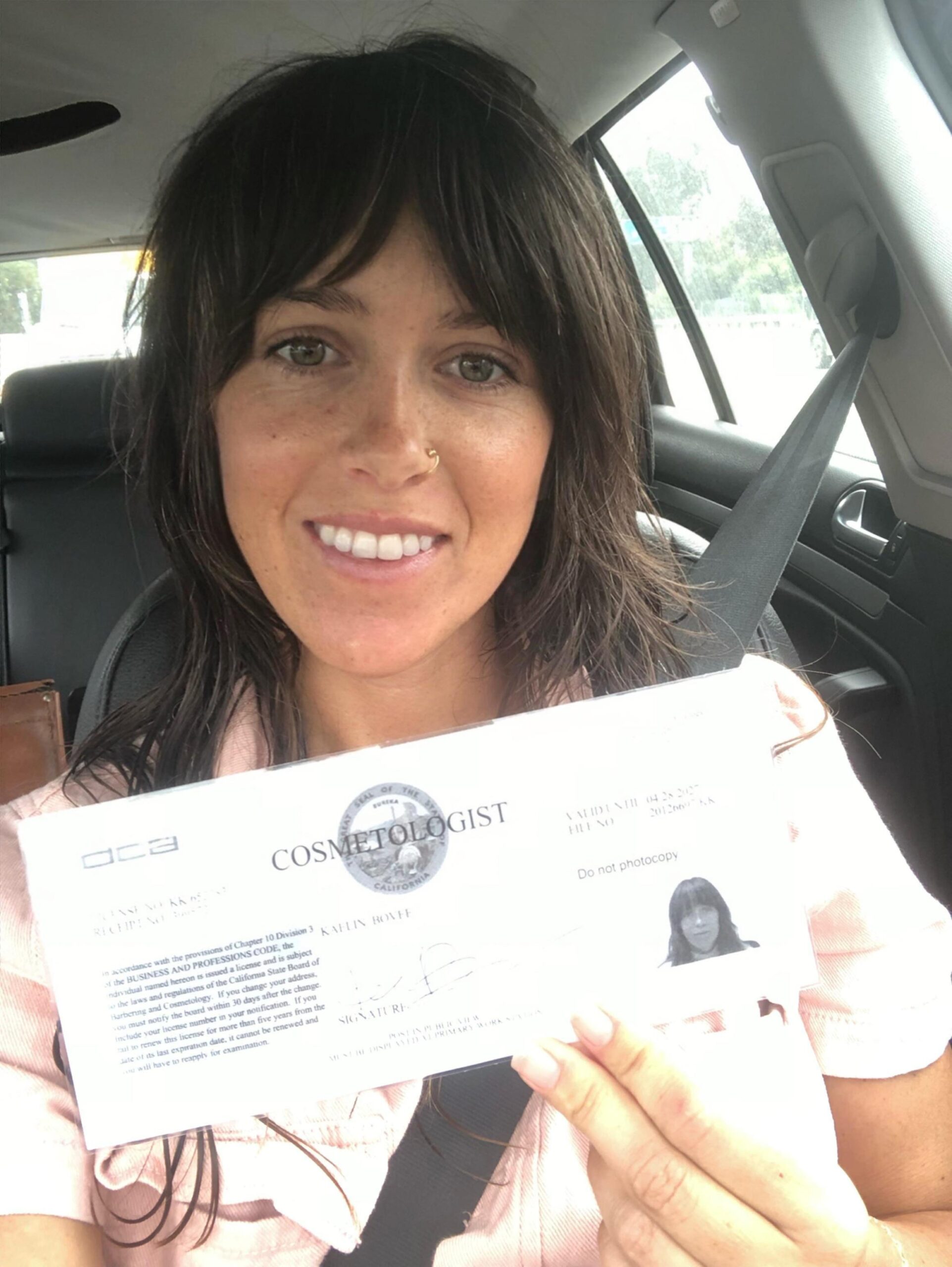 Kaelin Alexis holding her cosmetology license
